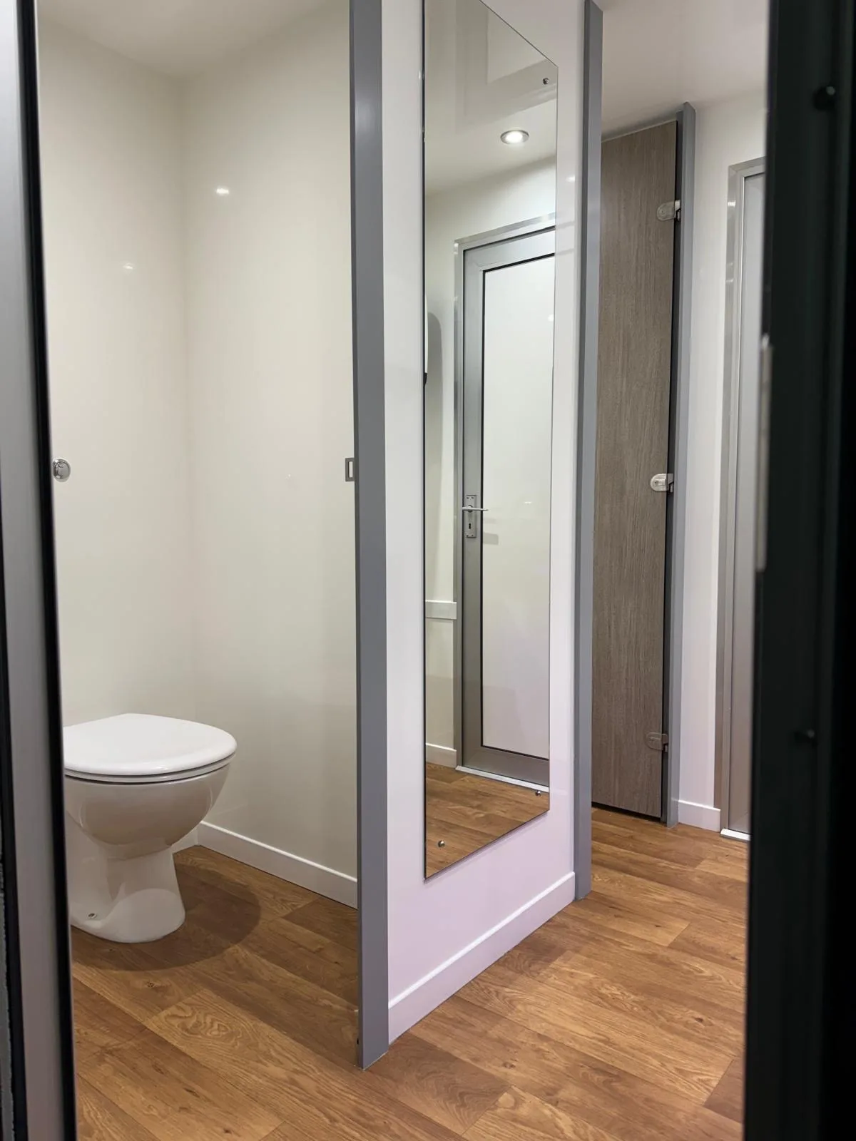2+1 mains luxury trailer cubicle with full-length mirrored door and oak wood-effect flooring