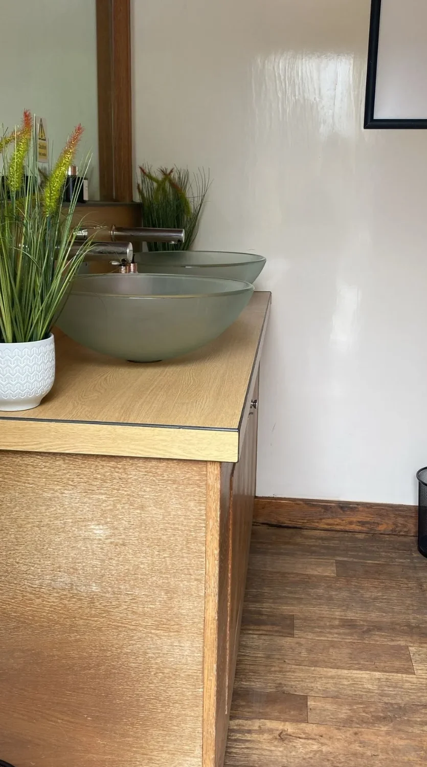3+3 luxury trailer vanity area showing Zebrano cabinetry and wood flooring
